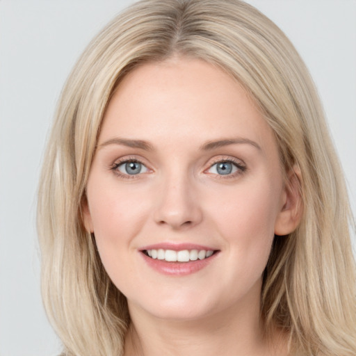 Joyful white young-adult female with long  brown hair and blue eyes