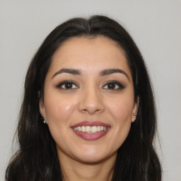 Joyful white young-adult female with long  brown hair and brown eyes