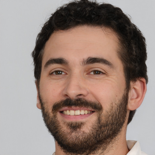 Joyful white young-adult male with short  black hair and brown eyes