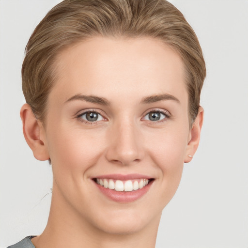 Joyful white young-adult female with short  brown hair and grey eyes