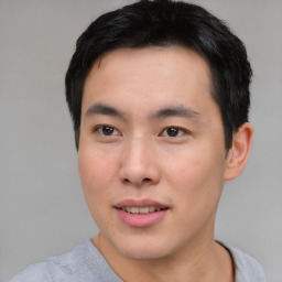 Joyful asian young-adult male with short  black hair and brown eyes