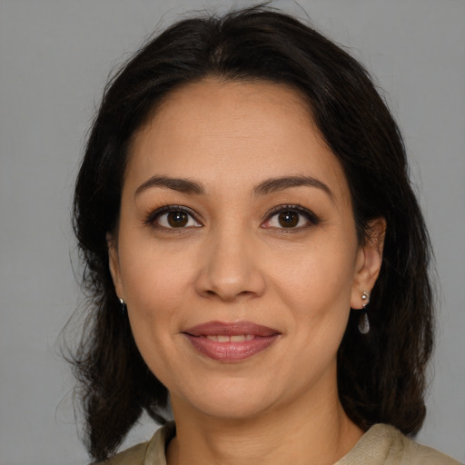 Joyful latino adult female with medium  brown hair and brown eyes