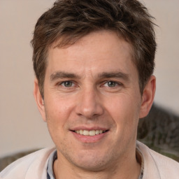 Joyful white adult male with short  brown hair and brown eyes