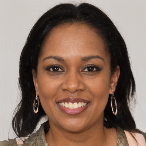 Joyful black young-adult female with long  brown hair and brown eyes