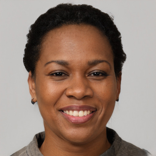 Joyful black adult female with short  black hair and brown eyes