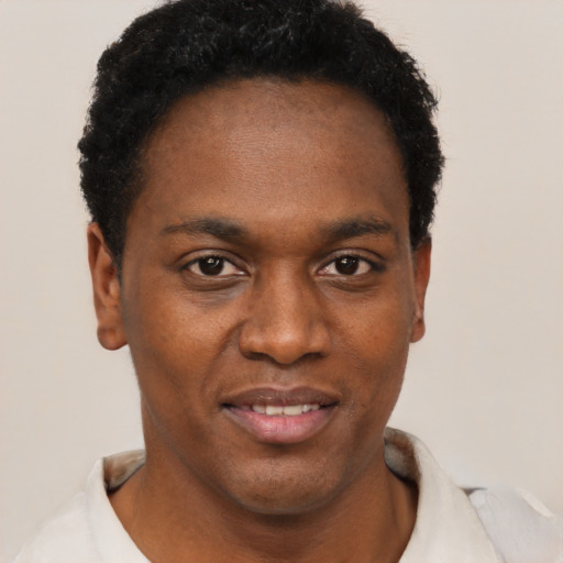 Joyful black young-adult male with short  black hair and brown eyes