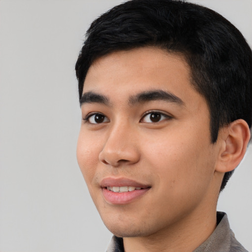 Joyful asian young-adult male with short  black hair and brown eyes