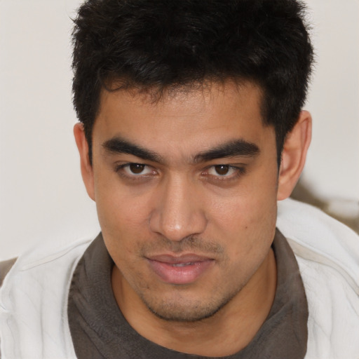Joyful asian young-adult male with short  brown hair and brown eyes