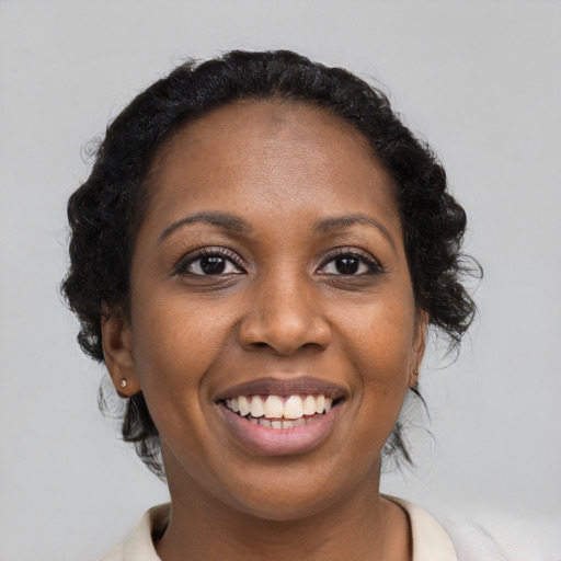 Joyful black young-adult female with medium  brown hair and brown eyes
