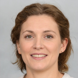 Joyful white young-adult female with medium  brown hair and green eyes