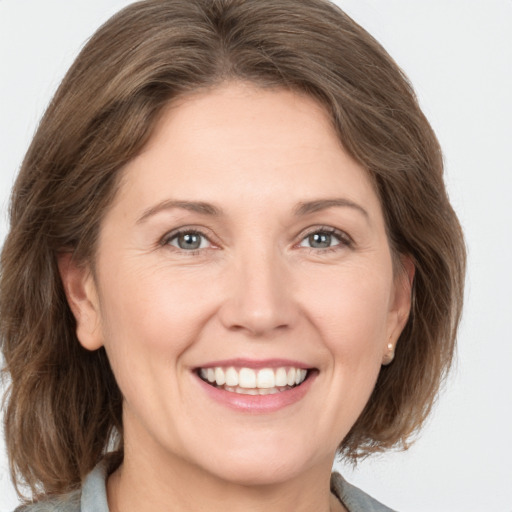 Joyful white adult female with medium  brown hair and grey eyes