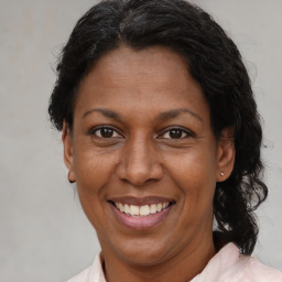 Joyful latino adult female with medium  brown hair and brown eyes