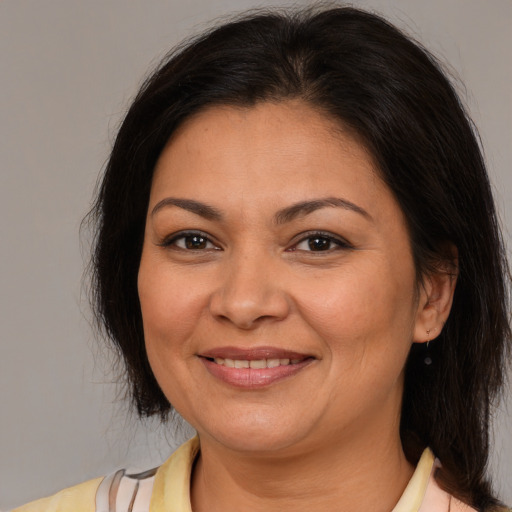 Joyful latino adult female with medium  brown hair and brown eyes