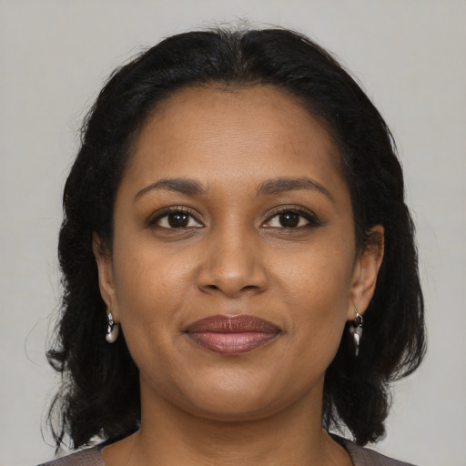 Joyful black young-adult female with medium  brown hair and brown eyes