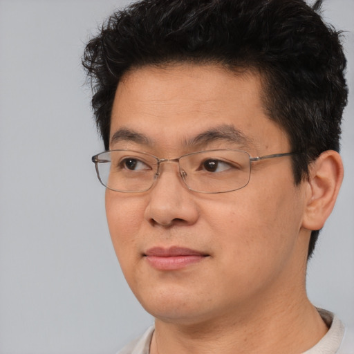 Joyful asian young-adult male with short  brown hair and brown eyes