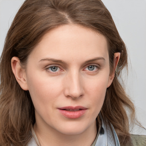 Joyful white young-adult female with long  brown hair and blue eyes