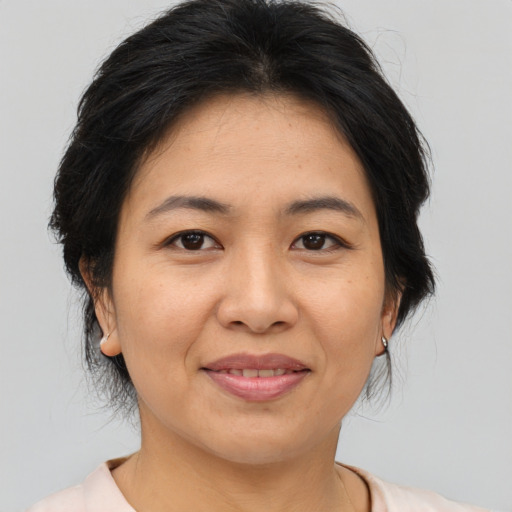 Joyful asian adult female with medium  brown hair and brown eyes
