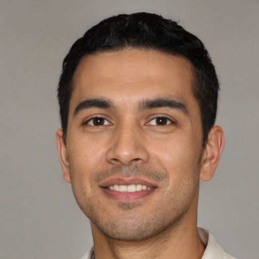 Joyful white young-adult male with short  black hair and brown eyes