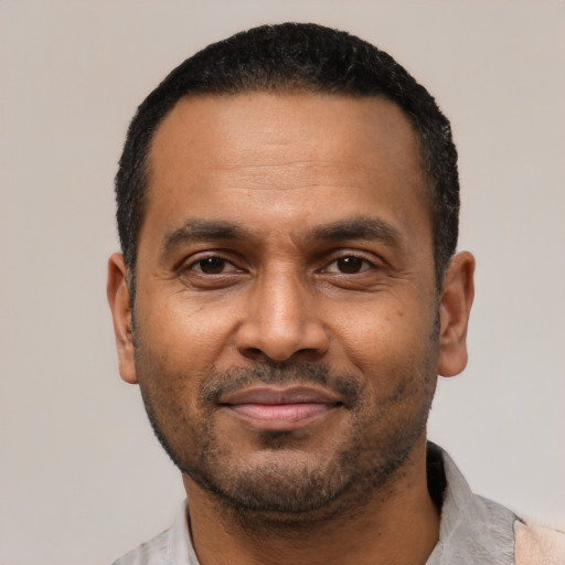 Joyful latino adult male with short  black hair and brown eyes