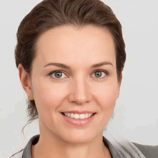 Joyful white young-adult female with short  brown hair and grey eyes