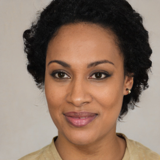 Joyful black young-adult female with long  black hair and brown eyes