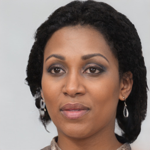 Joyful black young-adult female with long  black hair and brown eyes