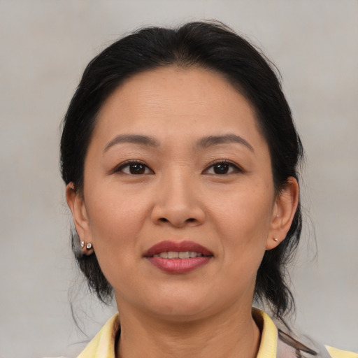 Joyful asian adult female with medium  brown hair and brown eyes