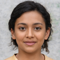 Joyful latino young-adult female with medium  brown hair and brown eyes