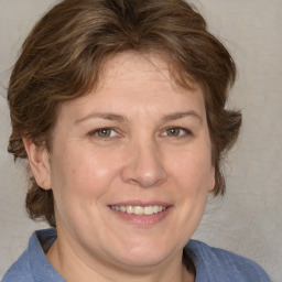 Joyful white adult female with medium  brown hair and blue eyes