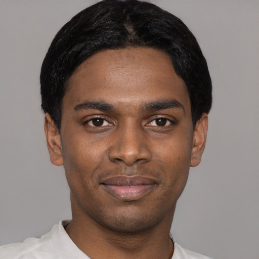 Joyful black young-adult male with short  black hair and brown eyes