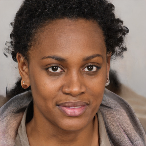 Joyful black young-adult female with short  brown hair and brown eyes