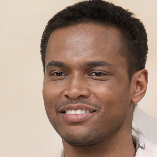 Joyful black young-adult male with short  brown hair and brown eyes