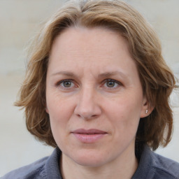 Joyful white adult female with medium  brown hair and blue eyes