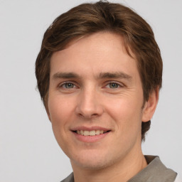 Joyful white young-adult male with short  brown hair and grey eyes