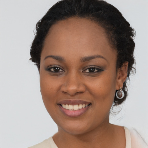 Joyful black young-adult female with long  black hair and brown eyes