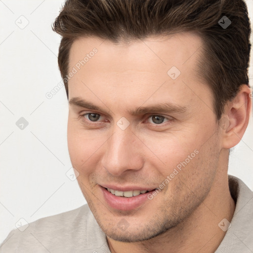 Joyful white young-adult male with short  brown hair and brown eyes