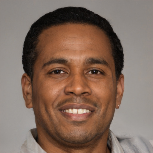 Joyful latino adult male with short  brown hair and brown eyes