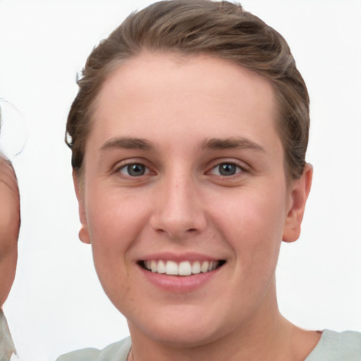 Joyful white young-adult female with short  brown hair and grey eyes