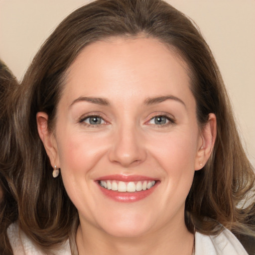 Joyful white adult female with medium  brown hair and grey eyes