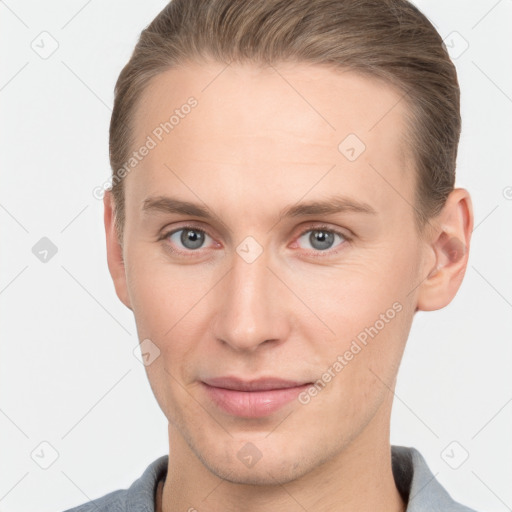 Joyful white young-adult male with short  brown hair and grey eyes