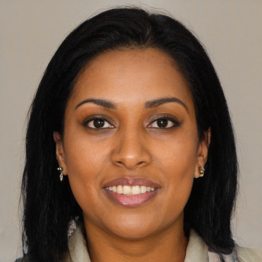 Joyful black young-adult female with long  black hair and brown eyes