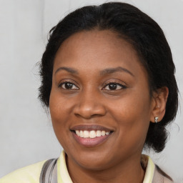 Joyful black young-adult female with medium  brown hair and brown eyes