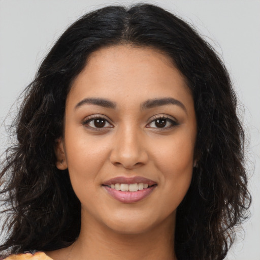 Joyful latino young-adult female with long  brown hair and brown eyes