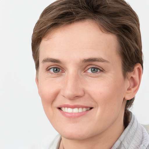 Joyful white young-adult female with short  brown hair and grey eyes