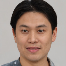 Joyful asian young-adult male with short  brown hair and brown eyes