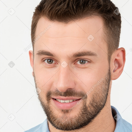 Joyful white young-adult male with short  brown hair and brown eyes