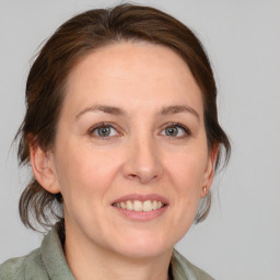 Joyful white adult female with medium  brown hair and grey eyes