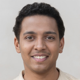 Joyful latino young-adult male with short  brown hair and brown eyes