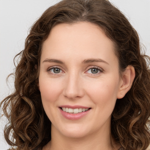 Joyful white young-adult female with long  brown hair and green eyes