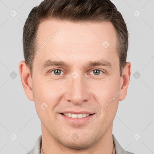 Joyful white young-adult male with short  brown hair and grey eyes